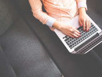 Frau tippt auf einer Notebook-Tastatur.