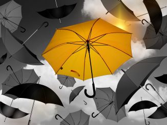 Gelber Regenschirm umgeben von grauen und schwarzen Regenschirmen.